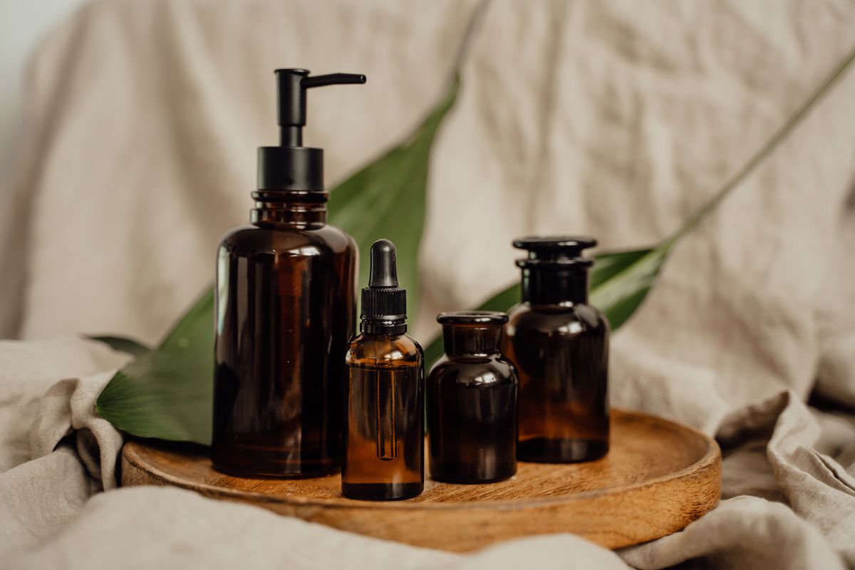 Amber glass apothecary bottles on a wooden tray